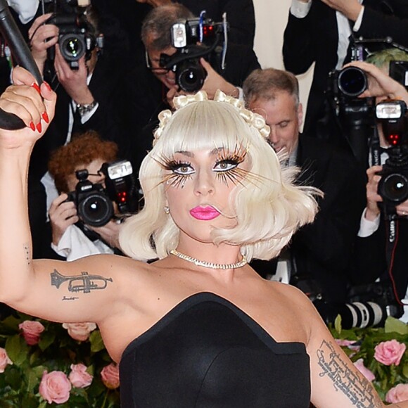 Lady Gaga fait un striptease lors de son arrivée à la 71e édition du MET Gala sur le thème "Camp: Notes on Fashion" au Costume Intitute du Metropolitan Museum of Art à New York, le 6 mai 2019.