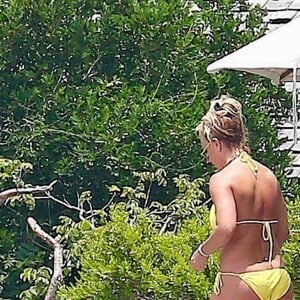 Exclusif - Britney Spears et sa mère Lynn en vacances sur les Îles Turks et Caïques le 22 juin 2019. Sur le film de ses vacances, Britney n'hésite pas à faire ses cascades elle-même. Elle escalade un rocher à mains nues et en tong sous l'oeil rassurant de sa mère. Aucune autre protection que son petit bikini jaune. Après cette montée d'adrénaline, la chanteuse fait trempette dans les eaux bleues de la crique et le duo mère - fille rejoint les transats.