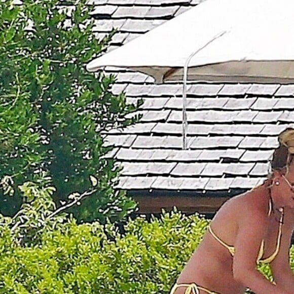Exclusif - Britney Spears et sa mère Lynn en vacances sur les Îles Turks et Caïques le 22 juin 2019. Sur le film de ses vacances, Britney n'hésite pas à faire ses cascades elle-même. Elle escalade un rocher à mains nues et en tong sous l'oeil rassurant de sa mère. Aucune autre protection que son petit bikini jaune. Après cette montée d'adrénaline, la chanteuse fait trempette dans les eaux bleues de la crique et le duo mère - fille rejoint les transats.