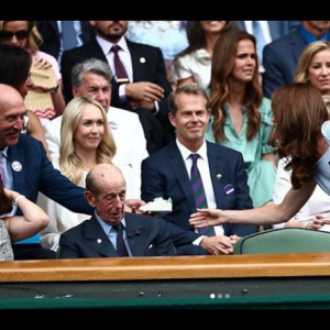 L'ex-champion de tennis Stan Smith offre une paire de baskets dédicacées à Kate Middleton pour son fils le prince Louis, au tournoi de Wimbledon, le 14 juillet 2019.