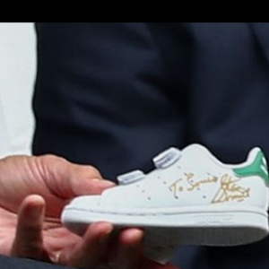 L'ex-champion de tennis Stan Smith offre une paire de baskets dédicacées à Kate Middleton pour son fils le prince Louis, au tournoi de Wimbledon, le 14 juillet 2019.