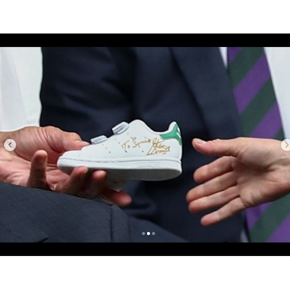 L'ex-champion de tennis Stan Smith offre une paire de baskets dédicacées à Kate Middleton pour son fils le prince Louis, au tournoi de Wimbledon, le 14 juillet 2019.