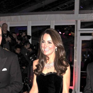 Kate Middleton en robe de soirée noire avec le prince William et le prince Harry à Londres en 2011.