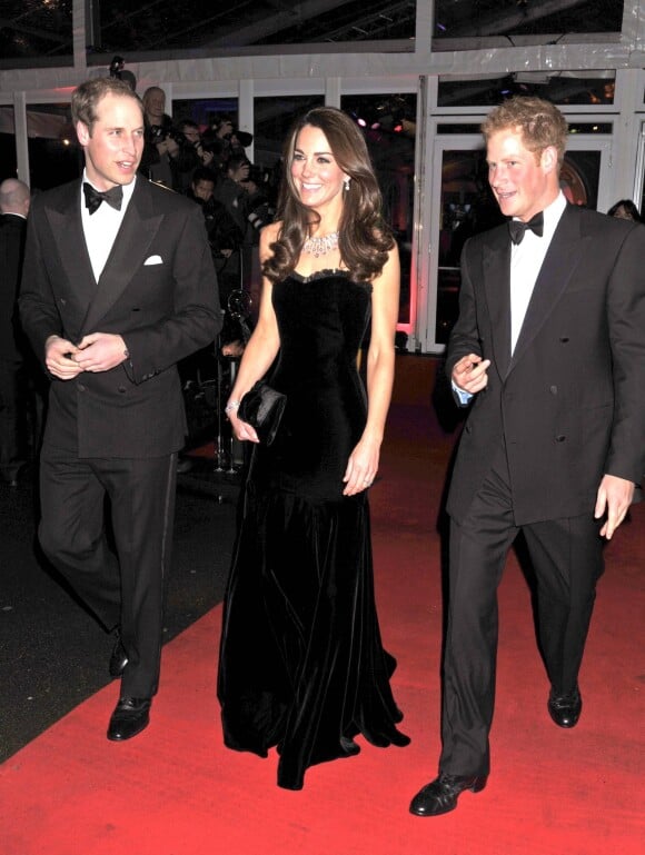 Kate Middleton en robe de soirée noire avec le prince William et le prince Harry à Londres en 2011.