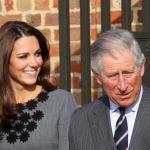 Kate Middleton en robe plissée grise avec le prince Charles à Londres, en 2012.