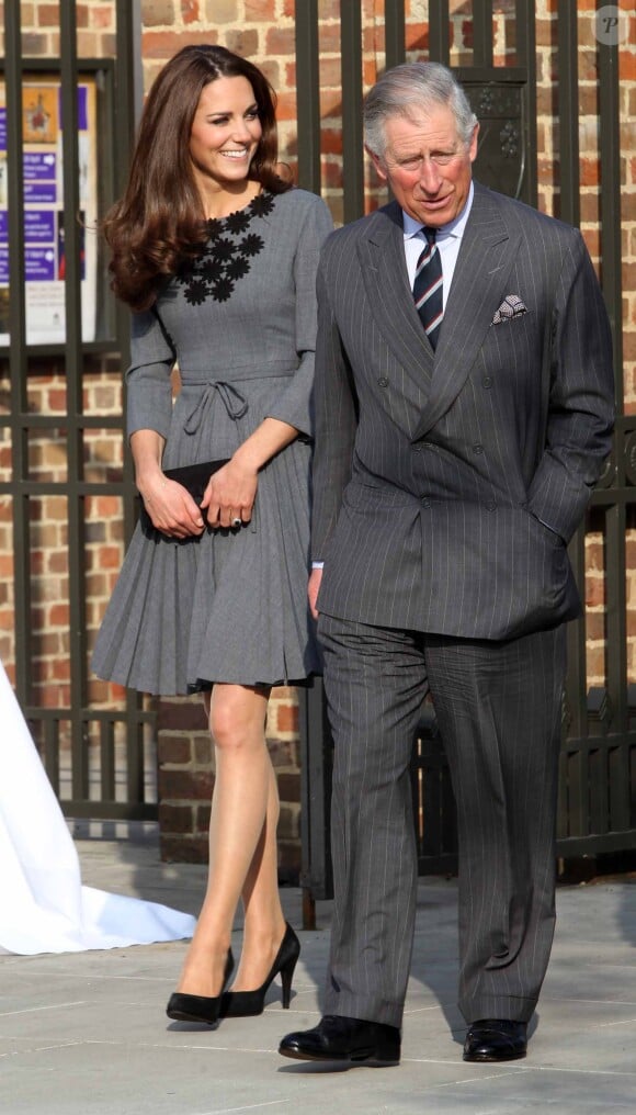 Kate Middleton en robe plissée grise avec le prince Charles à Londres, en 2012.