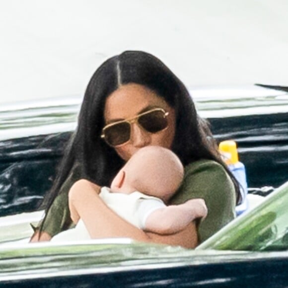 Meghan Markle, duchesse de Sussex, avec son fils Archie dans les bras le 10 juillet 2019 dans le Berkshire lors d'un tournoi de polo disputé par le prince Harry à Wokinghan.