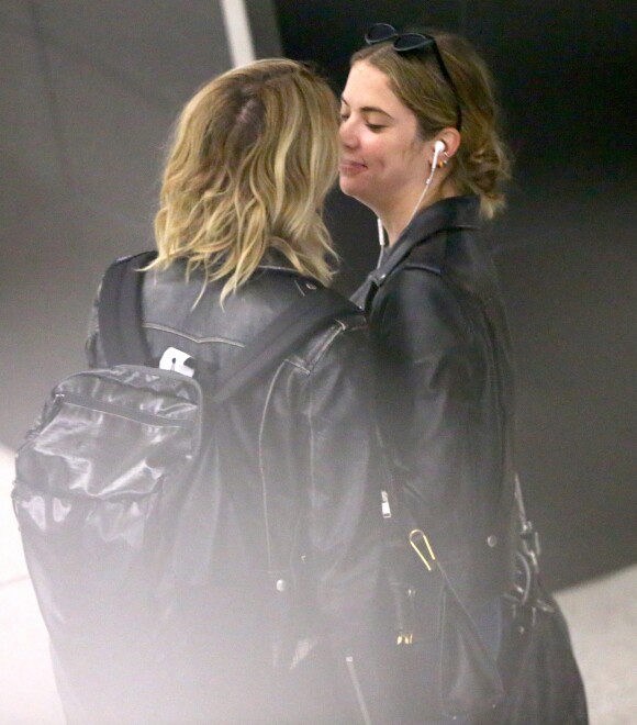Cara Delevingne et sa petite amie Ashley Benson arrivent à l'aéroport JFK de New York le 18 juin 2019. Le couple échange des baisers derrière la file de sécurité.