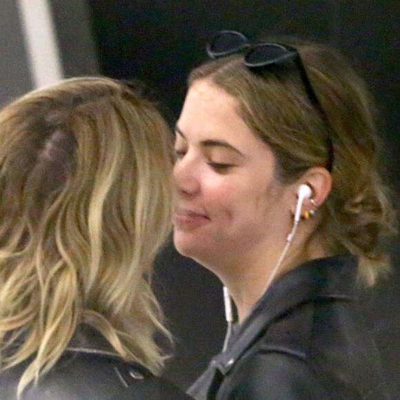 Cara Delevingne et sa petite amie Ashley Benson arrivent à l'aéroport JFK de New York le 18 juin 2019. Le couple échange des baisers derrière la file de sécurité.