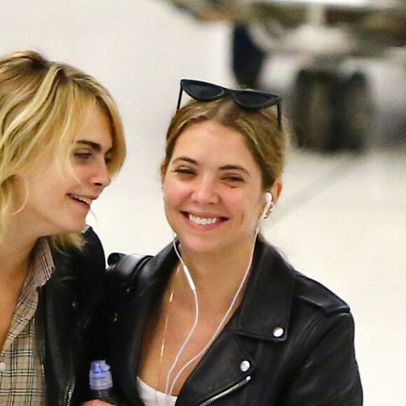 Cara Delevingne et sa petite amie Ashley Benson arrivent à l'aéroport JFK de New York le 18 juin 2019. Le couple échange des baisers derrière la file de sécurité.