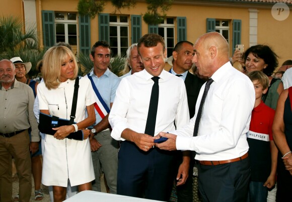 Emmanuel Macron, président de la République Française, et la Première dame Brigitte Macron (avec une attelle au bras droit) arrivent à la mairie de Bormes-les-Mimosas où ils sont accueillis par François Arizzi (maire de Bormes-les-Mimosas) lors de la cérémonie de commémoration du 75ème anniversaire de la libération de la ville de Bormes-les-Mimosas, le 17 août 2019. © Dominique Jacovides/Bestimage