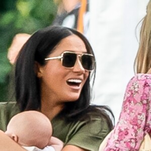 Meghan Markle, duchesse de Sussex, avec son fils Archie dans les bras lors d'un match de polo caritatif disputé par le prince Harry à Wokinghan le 10 juillet 2019.