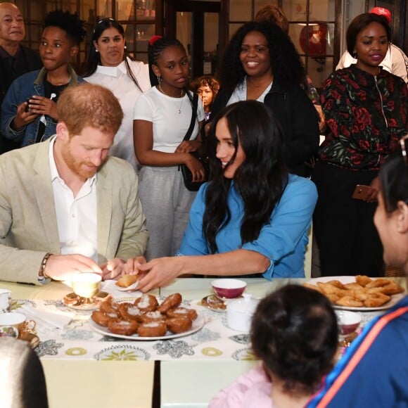 Le prince Harry, duc de Sussex, et Meghan Markle, duchesse de Sussex, en visite dans un e cuisine communautaire dans le District 6 au Cap dans le cadre de leur visite officielle en Afrique du Sud, le 23 septembre 2019.