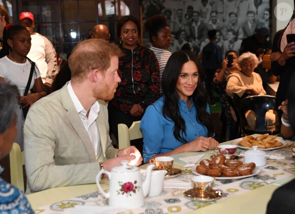 Le prince Harry, duc de Sussex, et Meghan Markle, duchesse de Sussex, en visite dans un e cuisine communautaire dans le District 6 au Cap dans le cadre de leur visite officielle en Afrique du Sud, le 23 septembre 2019.