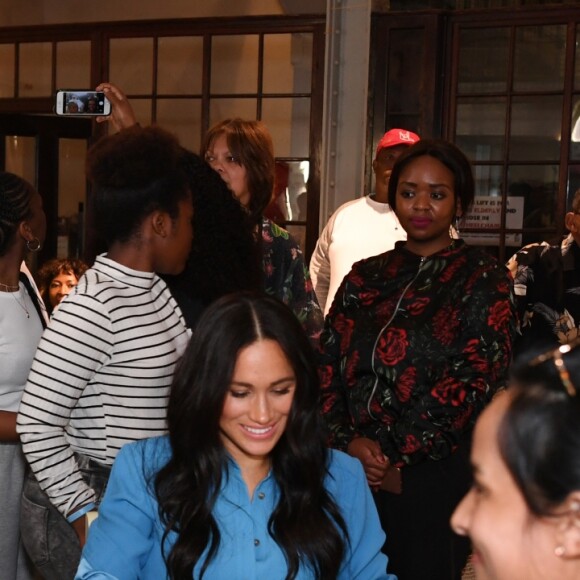 Le prince Harry, duc de Sussex, et Meghan Markle, duchesse de Sussex, en visite dans un e cuisine communautaire dans le District 6 au Cap dans le cadre de leur visite officielle en Afrique du Sud, le 23 septembre 2019.