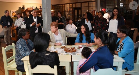 Le prince Harry, duc de Sussex, et Meghan Markle, duchesse de Sussex, en visite dans un e cuisine communautaire dans le District 6 au Cap dans le cadre de leur visite officielle en Afrique du Sud, le 23 septembre 2019.