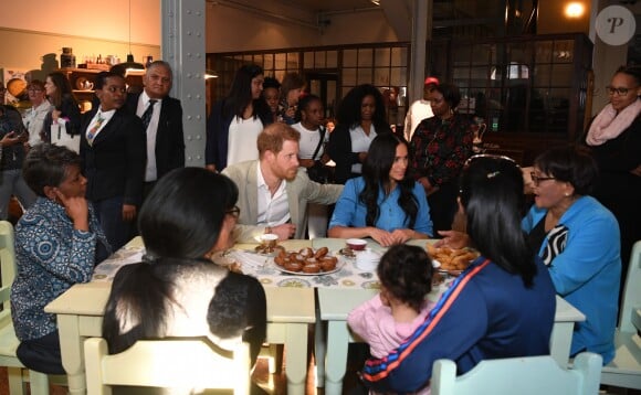 Le prince Harry, duc de Sussex, et Meghan Markle, duchesse de Sussex, en visite dans un e cuisine communautaire dans le District 6 au Cap dans le cadre de leur visite officielle en Afrique du Sud, le 23 septembre 2019.