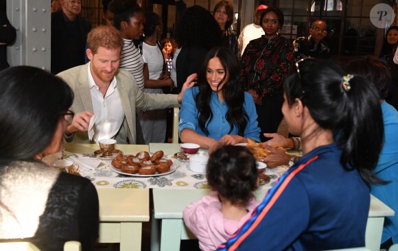 Le prince Harry, duc de Sussex, et Meghan Markle, duchesse de Sussex, en visite dans un e cuisine communautaire dans le District 6 au Cap dans le cadre de leur visite officielle en Afrique du Sud, le 23 septembre 2019.