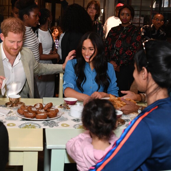 Le prince Harry, duc de Sussex, et Meghan Markle, duchesse de Sussex, en visite dans un e cuisine communautaire dans le District 6 au Cap dans le cadre de leur visite officielle en Afrique du Sud, le 23 septembre 2019.