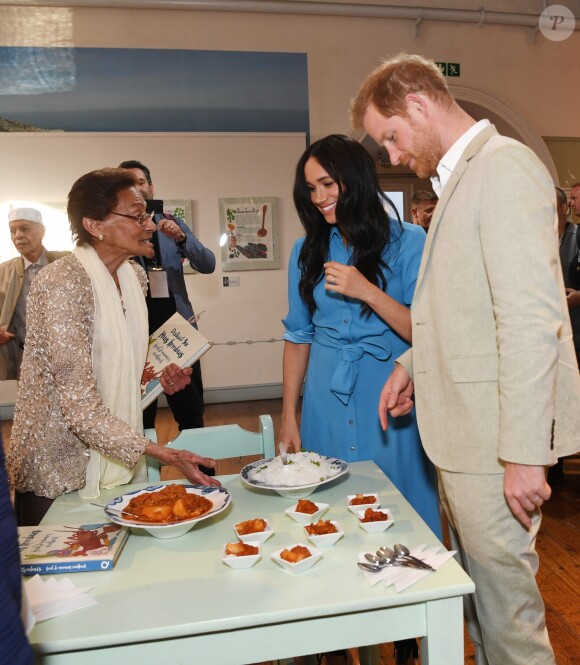 Le prince Harry, duc de Sussex, et Meghan Markle, duchesse de Sussex, en visite dans un e cuisine communautaire dans le District 6 au Cap dans le cadre de leur visite officielle en Afrique du Sud, le 23 septembre 2019.