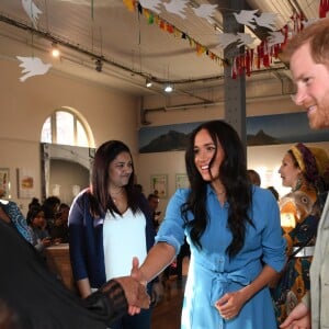 Le prince Harry, duc de Sussex, et Meghan Markle, duchesse de Sussex, en visite dans un e cuisine communautaire dans le District 6 au Cap dans le cadre de leur visite officielle en Afrique du Sud, le 23 septembre 2019.