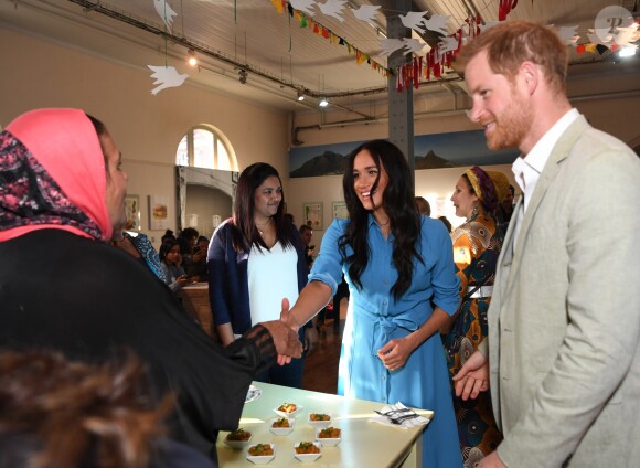 Le prince Harry, duc de Sussex, et Meghan Markle, duchesse de Sussex, en visite dans un e cuisine communautaire dans le District 6 au Cap dans le cadre de leur visite officielle en Afrique du Sud, le 23 septembre 2019.