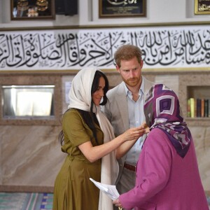 Meghan Markle, duchesse de Sussex, qui aide ici une fidèle à nouer son foulard, et le prince Harry ont visité la mosquée Auwal, la plus ancienne d'Afrique du Sud, dans le quartier de Bo-Kaap au Cap, le 24 septembre 2019 dans le cadre de leur visite officielle et de l'Heritage Day, un jour férié dans le pays.