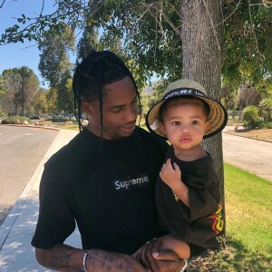 Travis Scott tient sa fille Stormi dans les bras - Instagram de Kylie Jenner.