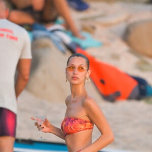 Bella Hadid - Bella Hadid s'amuse avec ses amis sur une plage de Saint-Barthélemy le 7 décembre 2019. Après un shooting le mannequin américain se baigne et sirote son cocktail avec ses amies sur un paddle géant au couché du soleil.