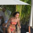 Bella Hadid - Bella Hadid s'amuse avec ses amis sur une plage de Saint-Barthélemy le 7 décembre 2019. Après un shooting le mannequin américain se baigne et sirote son cocktail avec ses amies sur un paddle géant au couché du soleil.