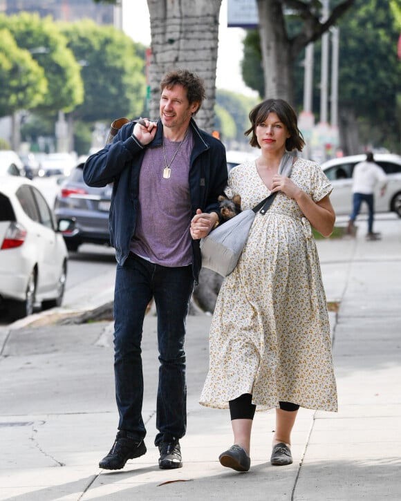 Exclusif - Milla Jovovich (enceinte) et son mari Paul W. S. Anderson se promènent avec leur chien dans les rues de Los Angeles. Le 16 janvier 2020.