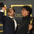 Le scénariste Han Jin-won et le réalisateur Bong Joon-ho, lauréats des prix du scénario original, du long métrage international, de la réalisation et du meilleur film pour "Parasite" au photocall de la Press Room de la 92ème cérémonie des Oscars 2019 au Hollywood and Highland à Los Angeles, Californie, Etats-Unis, le 9 février 2020.