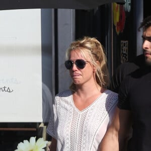 Exclusif - Britney Spears et son compagnon Sam Asghari sont allés déjeuner dans le restaurant 'Le Pain Quotidien' à Beverly Hills. Britney porte une blouse blanche transparente qui laisse entrevoir ses tétons. Le couple semble très amoureux, ils se tiennent la main alors qu'ils traversent la rue, le 12 juillet 2019.