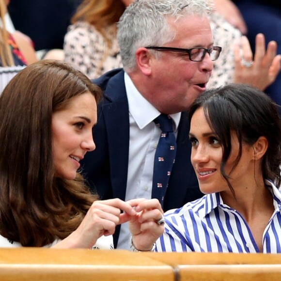 La duchesse Catherine de Cambridge (Kate Middleton) et la duchesse Meghan de Sussex (Meghan Markle) complices dans la royal box à Wimbledon le 14 juillet 2018.