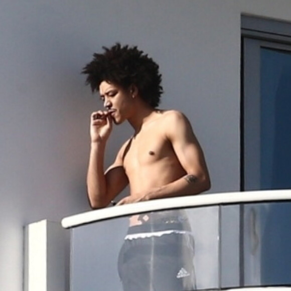 Ahlamalik Williams , le nouveau compagnon de Madonna, fume sur le balcon de son hôtel Faena à Miami. Le 14 décembre 2019.