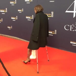 Charlotte Gainsbourg arrive avec des béquilles sur le tapis rouge de la 45e cérémonie des César, le 28 février 2020.