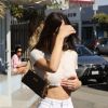 Kendall Jenner porte un jean taille haute blanc, un sac Louis Vuitton et un crop top sans soutien gorge à la sortie du restaurant Croft Alley dans le quartier de West Hollywood à Los Angeles, le 11 mars 2020.