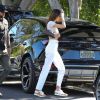 Kendall Jenner porte un jean taille haute blanc, un sac Louis Vuitton et un crop top sans soutien gorge à la sortie du restaurant Croft Alley dans le quartier de West Hollywood à Los Angeles, le 11 mars 2020.