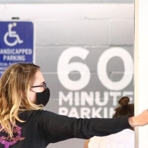 Grâce à un agent de sécurité, Ashley Benson et Cara Delevingne évitent un fan les prenant en photo, alors qu'elles chargent leurs courses dans leur voiture. L'agent de sécurité a fait barrage à l'admirateur envahissant dans le parking du supermarché "Erewhon" à Los Angeles, le 26 mars 2020.