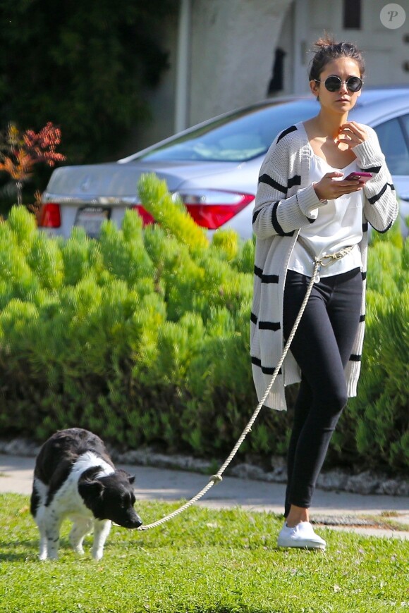 Concentrée sur son téléphone, Nina Dobrev oublie de ramasser les déjections de son chien lors de sa promenade à Beverly Hills, le 7 avril 2020.