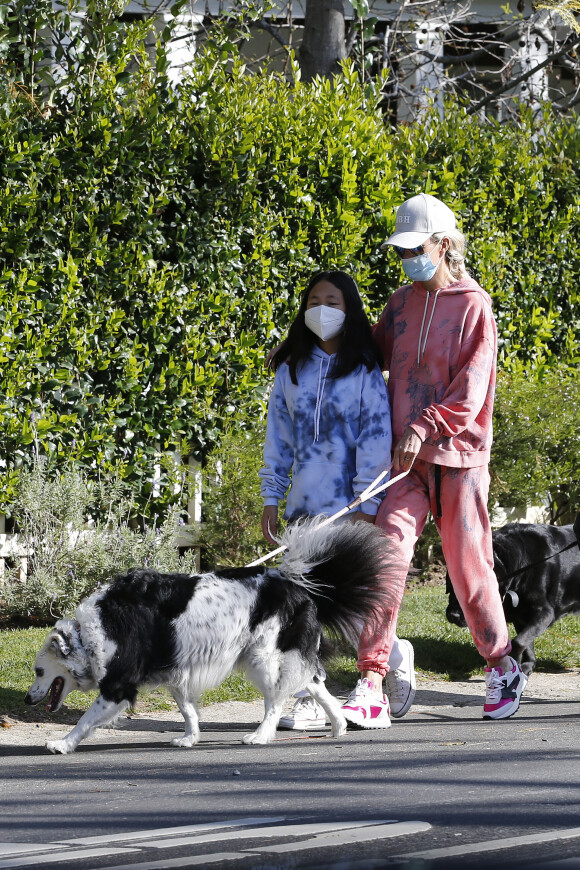 Laeticia Hallyday, ses filles Jade et Joy, Christina, avec des masques, et leurs chiens Santos, Cheyenne et Bono se promènent dans le quartier de Pacific Palisades, à Los Angeles, Californie, Etats-Unis, le 3 avril 2020, pendant la période de confinement.