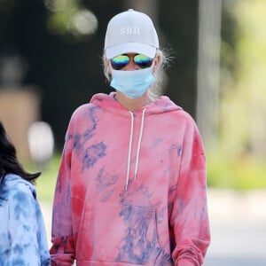 Laeticia Hallyday, ses filles Jade et Joy, Christina, avec des masques, et leurs chiens Santos, Cheyenne et Bono se promènent dans le quartier de Pacific Palisades, à Los Angeles, Californie, Etats-Unis, le 3 avril 2020, pendant la période de confinement.