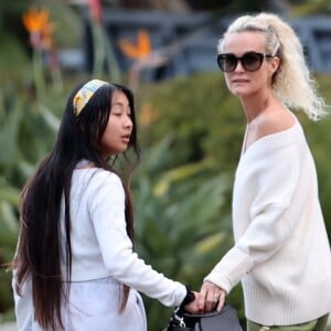 Laeticia Hallyday et ses filles Jade, 15 ans, et Joy, 11 ans, promènent leur chien Cheyenne dans le quartier de Brentwood à Los Angeles, pendant la période de confinement liée à l'épidémie de coronavirus (Covid-19), le 1er avril 2020.