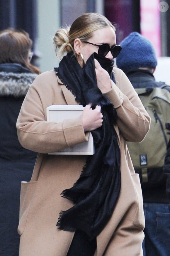 Exclusif - Adele se cache des photographes à la sortie d'un immeuble à New York, le 2 avril 2019.