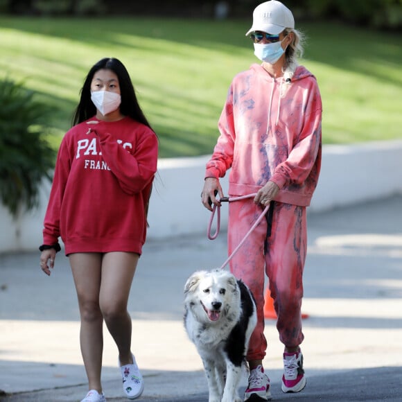 Christina arrive en fin d'après-midi chez Laeticia avec son chien Bono et des masques de protection à la main. Laeticia Hallyday, ses filles Jade et Joy, Christina, avec des masques, et leurs chiens Santos, Cheyenne et Bono se promènent dans le quartier de Pacific Palisades, à Los Angeles, Californie, Etats-Unis, le 3 avril 2020, pendant la période de confinement. Jade et Joy s'amusent avec leurs masques pendant la balade.