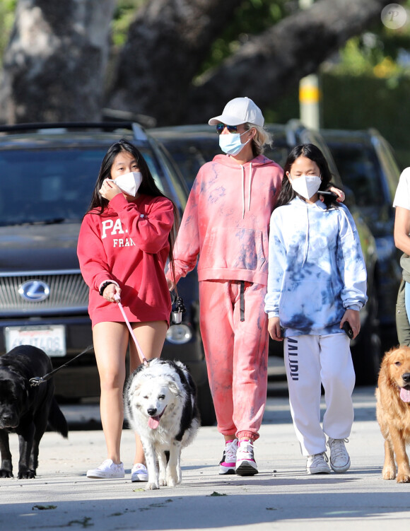 Christina arrive en fin d'après-midi chez Laeticia avec son chien Bono et des masques de protection à la main. Laeticia Hallyday, ses filles Jade et Joy, Christina, avec des masques, et leurs chiens Santos, Cheyenne et Bono se promènent dans le quartier de Pacific Palisades, à Los Angeles, Californie, Etats-Unis, le 3 avril 2020, pendant la période de confinement. Jade et Joy s'amusent avec leurs masques pendant la balade.