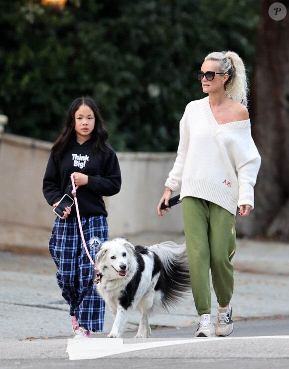Laeticia Hallyday et ses filles Jade, 15 ans, et Joy, 11 ans, promènent leur chien Cheyenne dans le quartier de Brentwood à Los Angeles, pendant la période de confinement liée à l'épidémie de coronavirus (Covid-19), le 1er avril 2020.