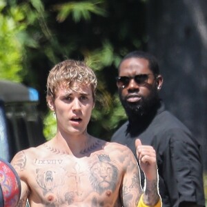 Justin Bieber, torse nu, joue au basket avec ses gardes du corps tandis que sa femme Hailey Baldwin-Bieber revient à la maison avec des boissons à Beverly Hills, le 25 mai 2020, jour du "Memorial Day" aux Etats-Unis.