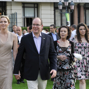 Le prince Albert II de Monaco et la princesse Charlene avec la baronne Elisabeth-Anne de Massy et sa fille Melanie-Antoinette Costello de Massy en juillet 2015 lors d'un dîner sur l'herbe pour le 150e anniversaire de la Société des Bains de Mer. Elisabeth-Ann de Massy est décédée à l'âge de 73 ans le 10 juin 2020 au Centre hospitalier princesse Grace.