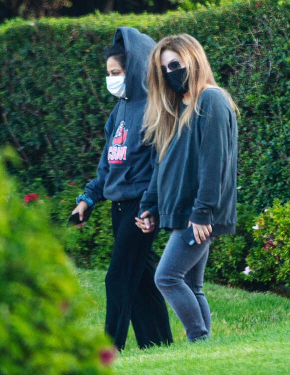 Exclusif - Lisa Marie Presley marche main dans la main avec Diana Pinto (la compagne de Benjamin Keough) dans le quartier de Beverly Hills à Los Angeles pendant l'épidémie de coronavirus (Covid-19). Les deux jeunes femmes se soutiennent depuis la mort de Benjamin. Le 15 juillet 2020
